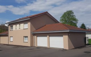 Maison rénovée avec façade isolée en finition beige et toitures rouges