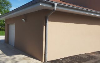 Détail d’un mur isolé avec finition beige et gouttière